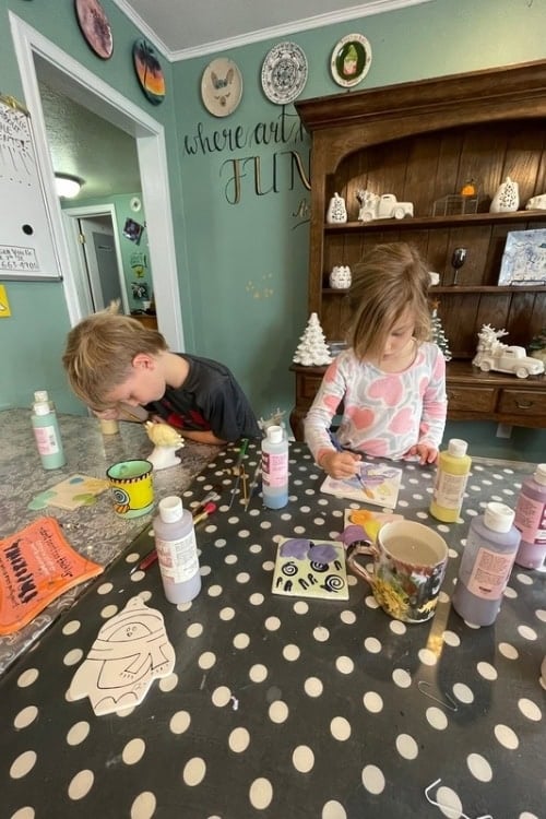 Person painting pottery at Artisan You