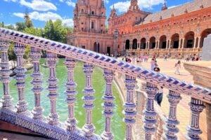 A bridge with blue porcelain handrail overlooks a canal at Plaza de España in Seville, Spain. Marybeth Bond