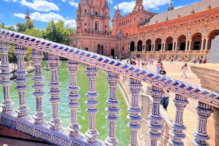 A bridge with blue porcelain handrail overlooks a canal at Plaza de España in Seville, Spain. Marybeth Bond