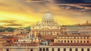 Evening light bathes St. Peter's Basilica and the Vatican's historic corridors. Image by Garsya from Getty Images via Canva