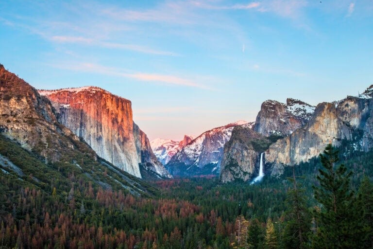 Yosemite Valley awakens at sunrise, with El Capitan's granite face glowing pink while Bridalveil Fall catches the morning light. Photo by Ericliu08 from Getty Images Pro via Canva