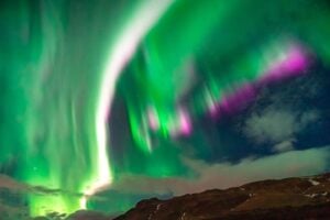 Aurora borealis with visible green and pink hues. Photo by Ramseit Cairos