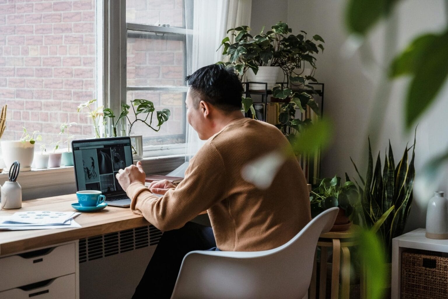 A man sitting on a chair while working on his laptop. Photo by Annushka Ahuja, Pexels