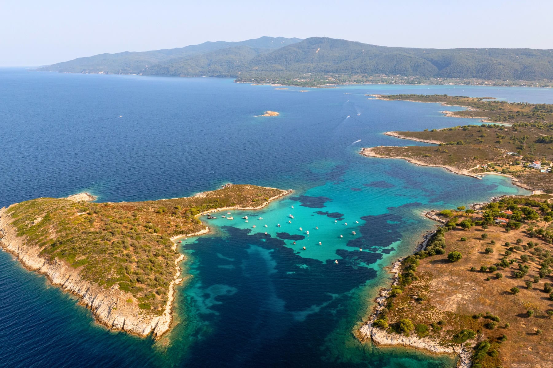 Diaporos island showing off its crystal clear turquoise water. Photo by Danil Rudenko via Canva
