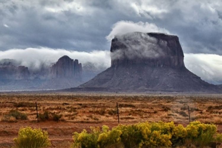Monument Valley in shrouded in morning clouds. Photo by Tab Hauser