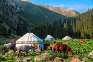 Iconic Kyrgyz yurts with horses in mountainous landscape, by nantonov, iStock