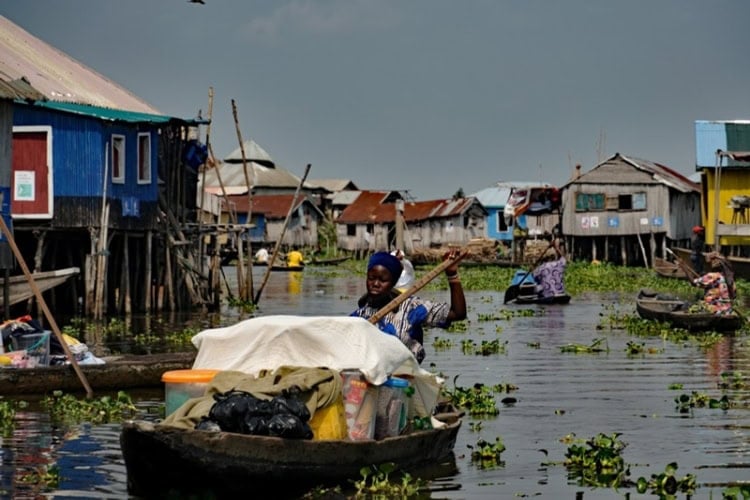 Merchant transporting her wares by boat in the stilt village of Ganvie. Photo by Edward Placidi