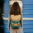 Traveler standing in front of a train. Photo by Getty Images, Unsplash