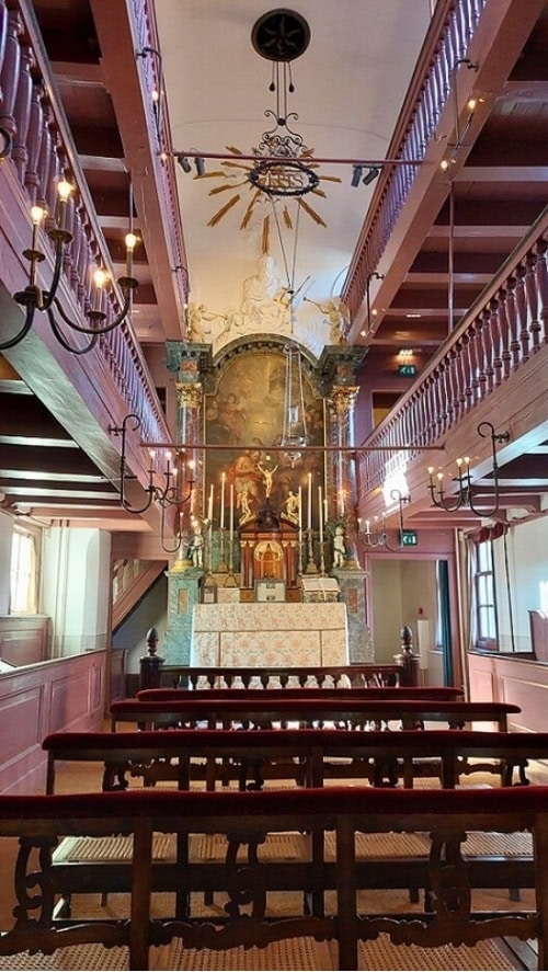The narrow nave of Our Lord in the Attic Museum with its Baroque altar, located in the upper stories of a canal house in Amsterdam. Photo by Richard Varr