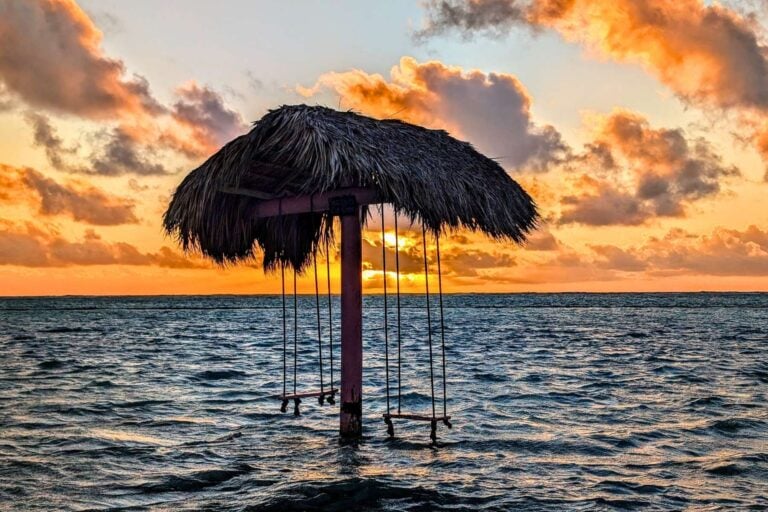 The sun rises over a palapa that stands offshore in the surf. Photo by Frank Hosek