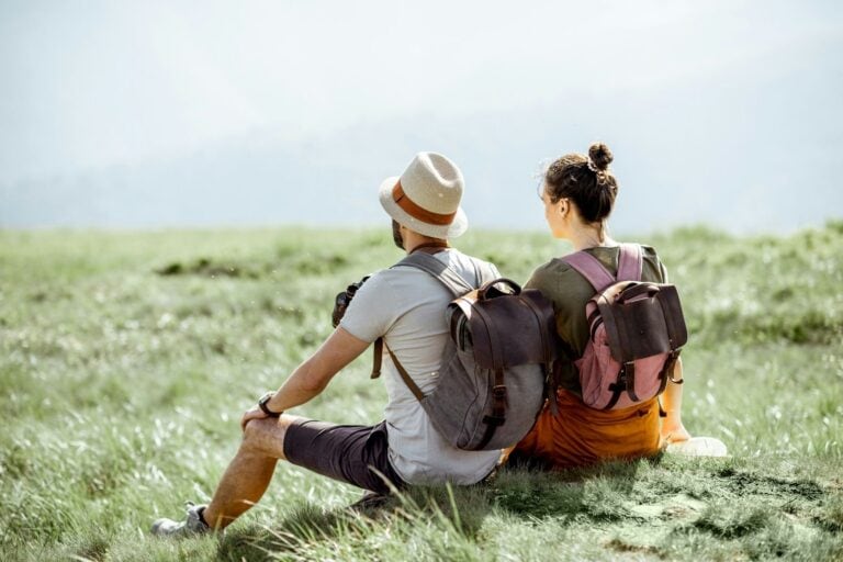 Two travelers sitting in nature. Photo by Getty Images, Unsplash