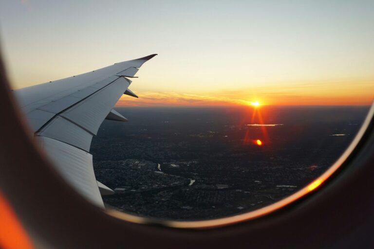 Airplanes window view of the sky during the golden hour. Photo by Eva Darron, Unsplash
