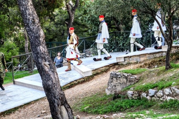 The Greek Presidential Guard, known as Evzones, conducts a weekly ceremony to raise and lower the Greek flag on the Acropolis of Athens at sunrise and sunset. Photo by Frank Hosek