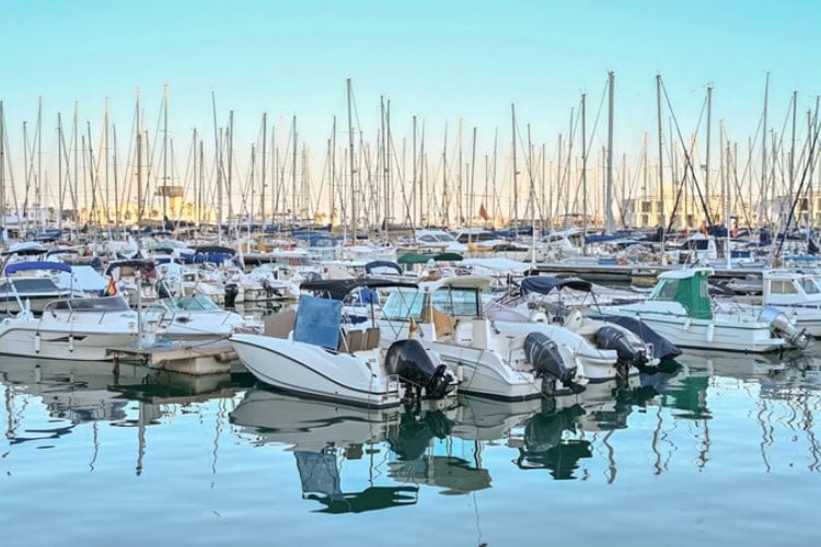Yachts and boats docked in a Mediterranean marina at sunset. Photo by [Author's Name]