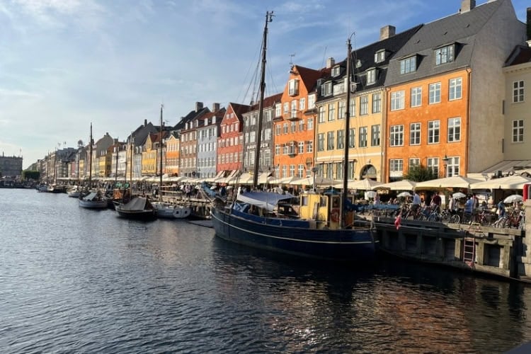 Nyhavn Canal in Copenhagen, Denmark, lined with colorful townhouses, cafes, and boats. Photo by Maureen C. Bruschi