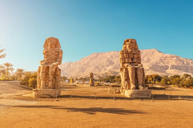 The famous Two Colossi of Memnon, massive ruined statues of Pharaoh Amenhotep III near Luxor, Egypt. Photo by Getty Images for Unsplash