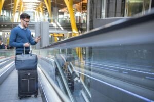 Young man on the escalator at the airport. Photo by Getty Images, Unsplash