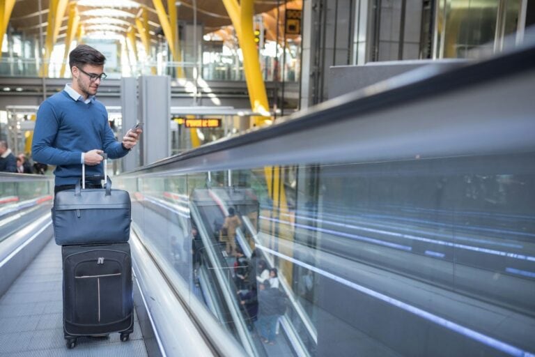 Young man on the escalator at the airport. Photo by Getty Images, Unsplash