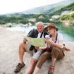 A senior couple on a hiking trip during their summer holiday, utilizing a map to navigate. Photo by Getty Images for Unsplash