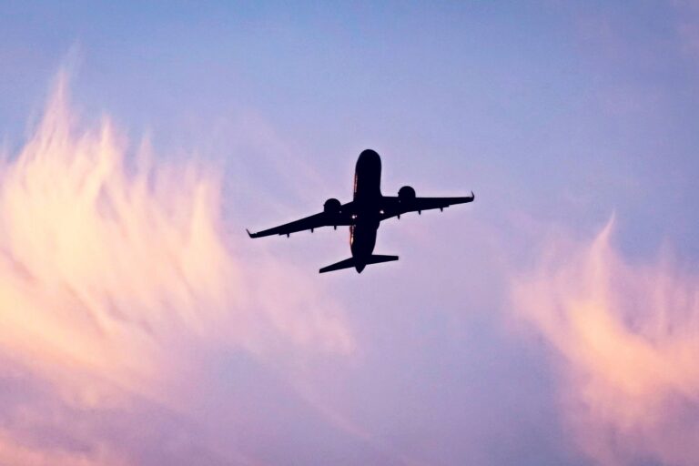Airplane silhouette ascending against a cloudy sky. Photo by Abdelhamid Azoui, Unsplash