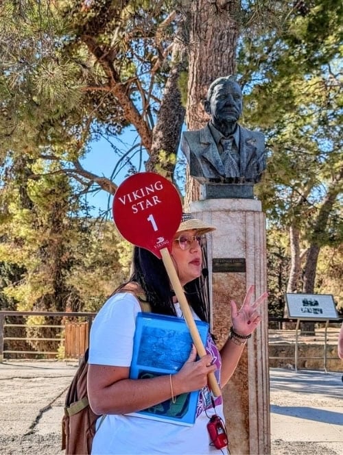 Our guide beneath the bust of Sir Arthur Evans at Knossos. Through Evans’ efforts, Knossos came to symbolize the greatness of Minoan society. Photo by Kathy Hosek