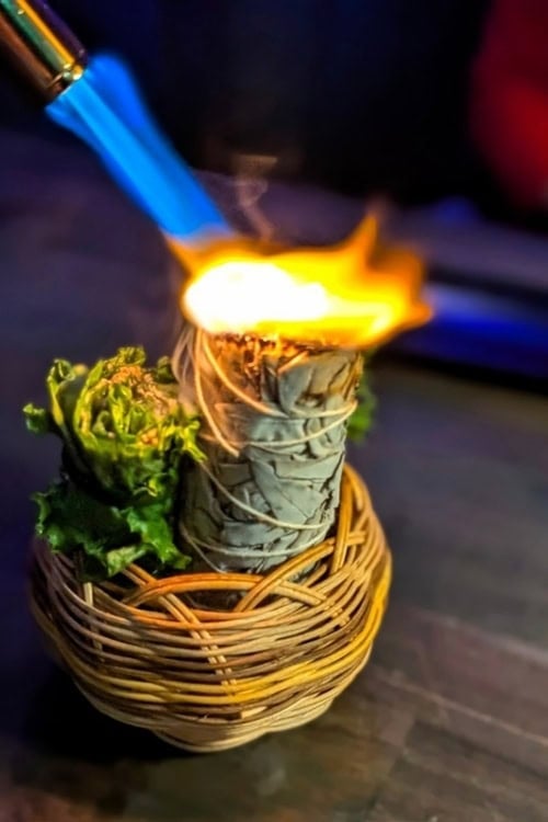 A handheld salad wrapping sumac and walnut pesto served with smoking sage, inspired by a Choctaw ceremonial ritual. Photo by Craig Stoltz