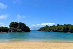 Lush shoreline and rock islets as seen from Ikei Beach in Okinawa, Japan. Photo by Liv Headley