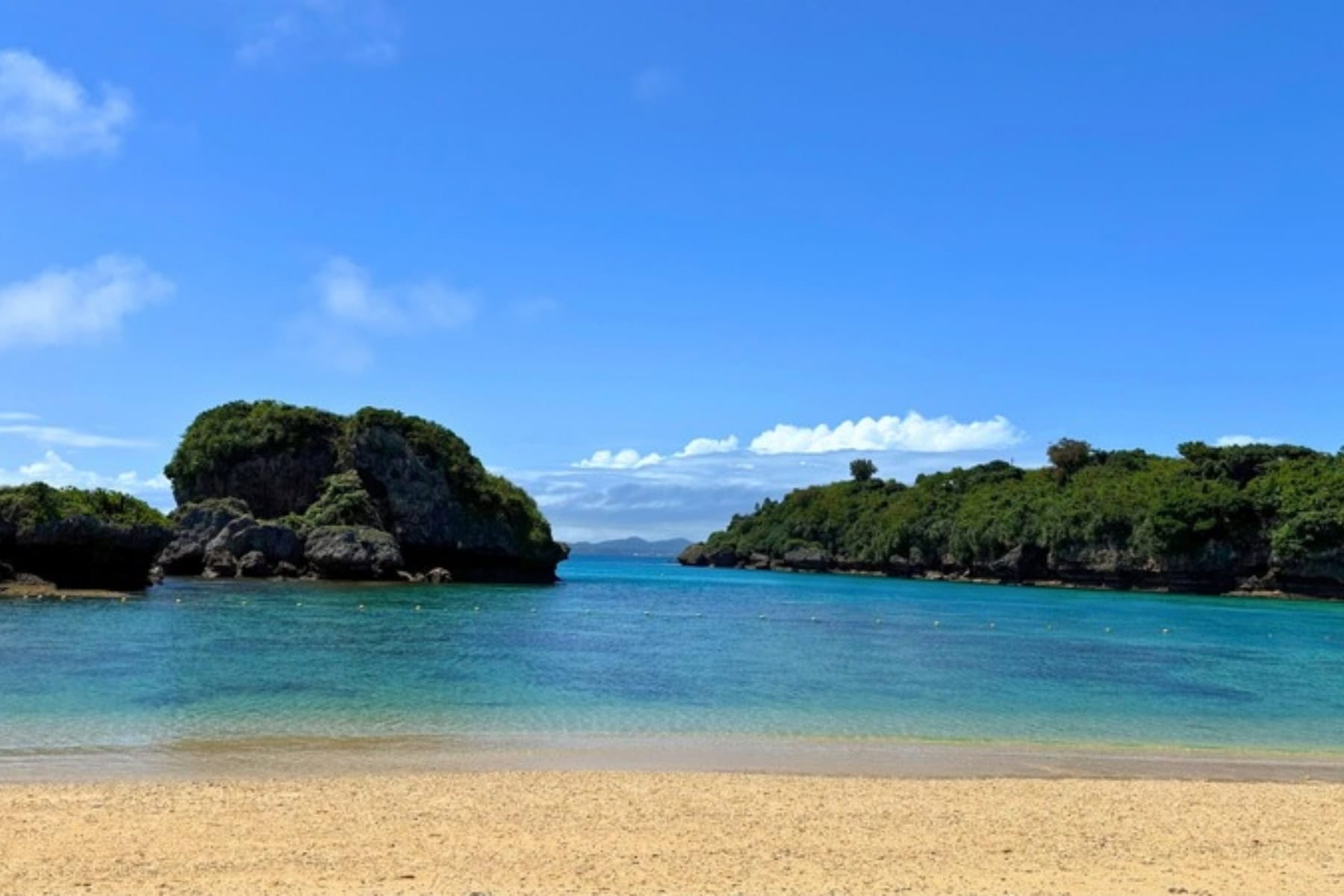 Lush shoreline and rock islets as seen from Ikei Beach in Okinawa, Japan. Photo by Liv Headley