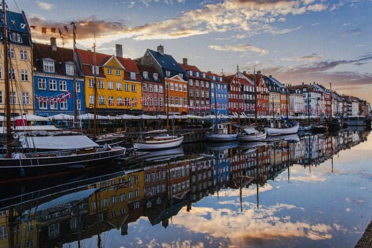 View of Nyhavn Canal area in Copenhagen, Denmark, at sunrise. Photo by Getty Images, Unsplash