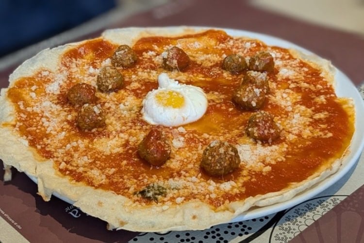Pane Frattau topped with meatballs and an egg