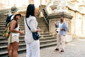 Tourists standing in front of stairs. Photo by Molly the Cat, Unsplash