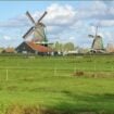 Towering windmills rising beside the river at Zaanse Schans. Photo by Huyen Tran Pinterest
