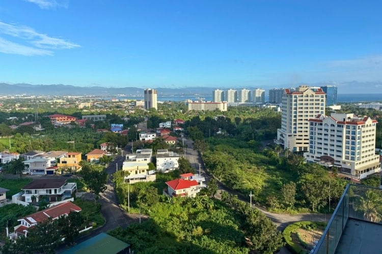 View over residential buildings on Mactan Island, with the sea and mountains in the distance. Photo by Nikola Mikovic