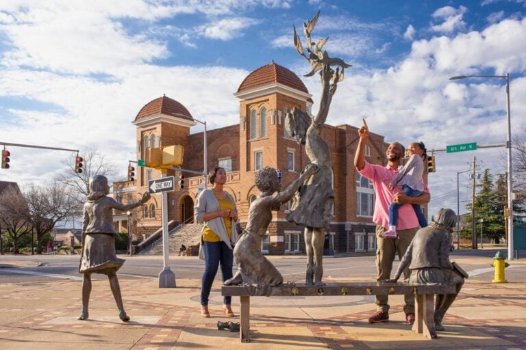 A family with The Four Spirits statue in front of 16th Street Baptist Church. Photo courtesy of the Greater Birmingham Convention and Visitors Bureau