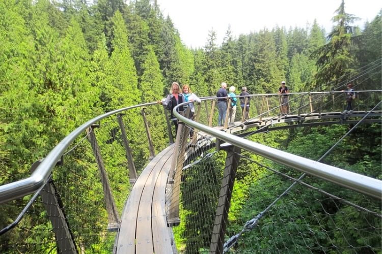 Sue Fisher and another person pose on the Cliffwalk above Capilano Canyon. Photo by Capilano Suspension Bridge worker