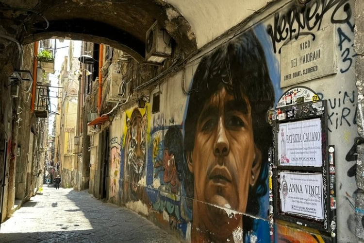 A mural of football player and local hero, Diego Maradona in a Naples alley. Photo by Steve Sindiong
