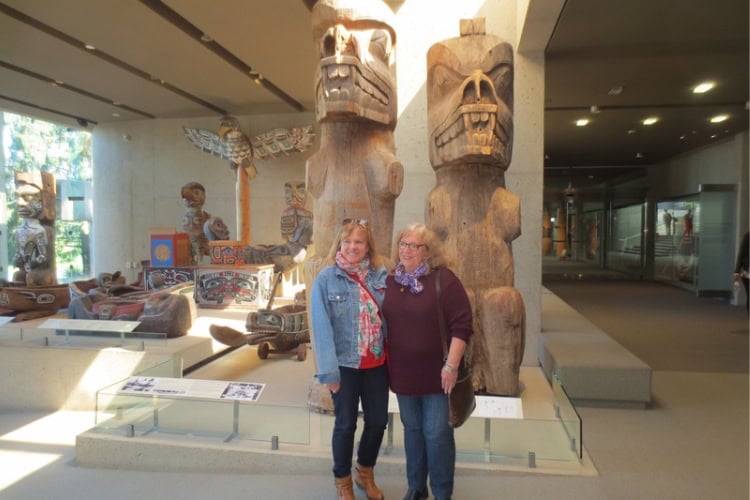 Writer poses with her sister, Katherine, in front of totems. Photo by staff member