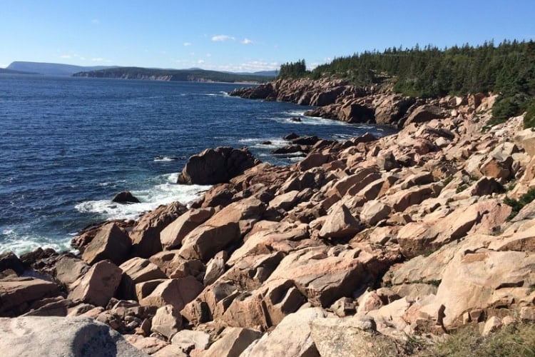 Shoreline of ruddy-coloured boulders in Cape Breton Highlands National Park. Photo by Brent Cassie