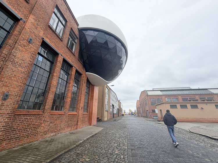 Niemeyer Sphere, is a futuristic, spaceship-like architectural annex perched on a historic industrial building in Leipzig, Germany. Designed by the legendary Brazilian architect Oscar Niemeyer in 2011, it is notably his final project before he passed away in 2012. Photo by Janna Graber