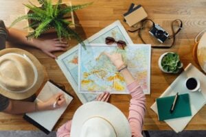 A young couple plans a vacation trip using maps. Photo by Getty Images, Unsplash