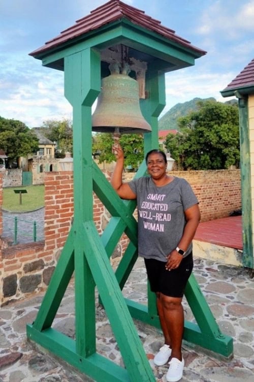Ms. Michelle Woodley van Putten, the island's official bell ringer on Statia. Photo by [Copyright Owner's Name]