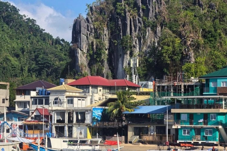 Boats line the waterfront beneath limestone cliffs in El Nido town, Palawan, Philippines. Photo by Kurl Ivan I. Fernandez