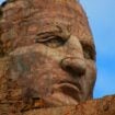 The 87-foot tall face of Crazy Horse, a full one-third taller than any face on Mount Rushmore, dwarfs a yellow crawler tractor in 2010. Photo by Frank Hosek