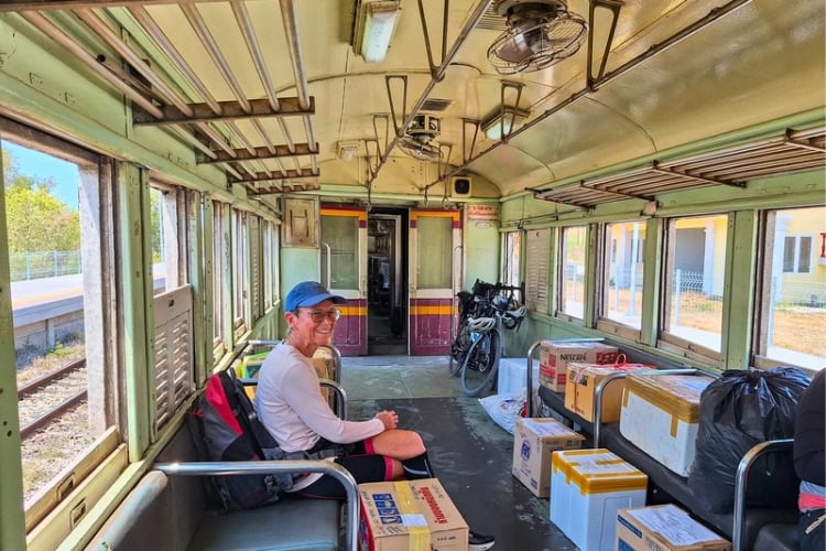 Cyclist inside a Thai train freight carriage during a 15-minute journey from Huai Yang. Photo by Michael Cullen