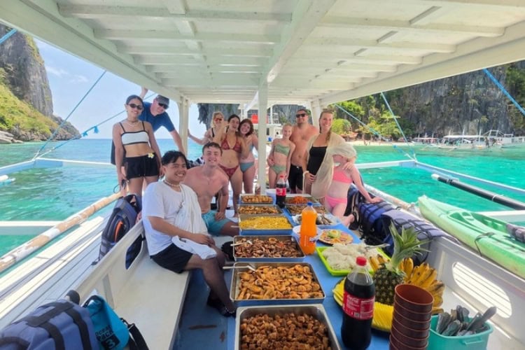 Travelers share lunch aboard an island-hopping boat in El Nido, Palawan, Philippines. Photo by Kurl Ivan I. Fernandez