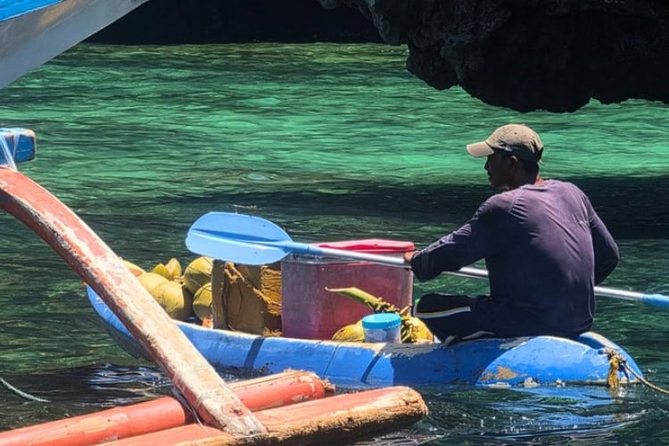A local vendor paddles beside an island-hopping boat in El Nido, Palawan, Philippines. Photo by Kurl Ivan I. Fernandez