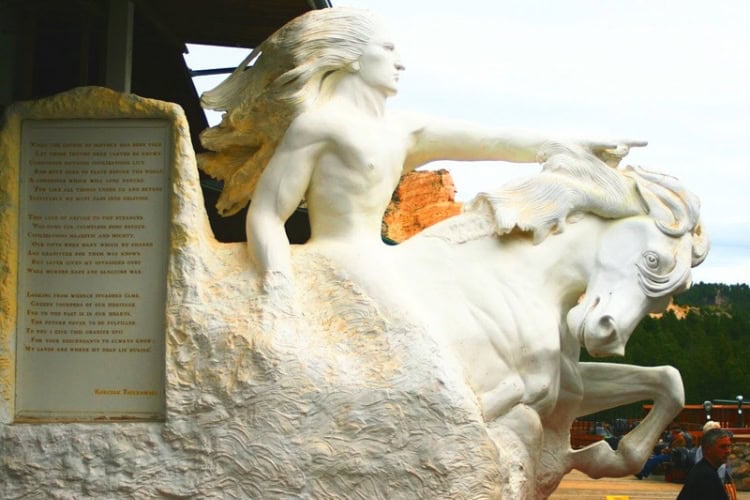 A model of the Crazy Horse Memorial, displayed on the pavilion of the Visitor Center, depicting Crazy Horse, with wind-blown hair, astride his horse as he points toward the horizon. Photo by Frank Hosek