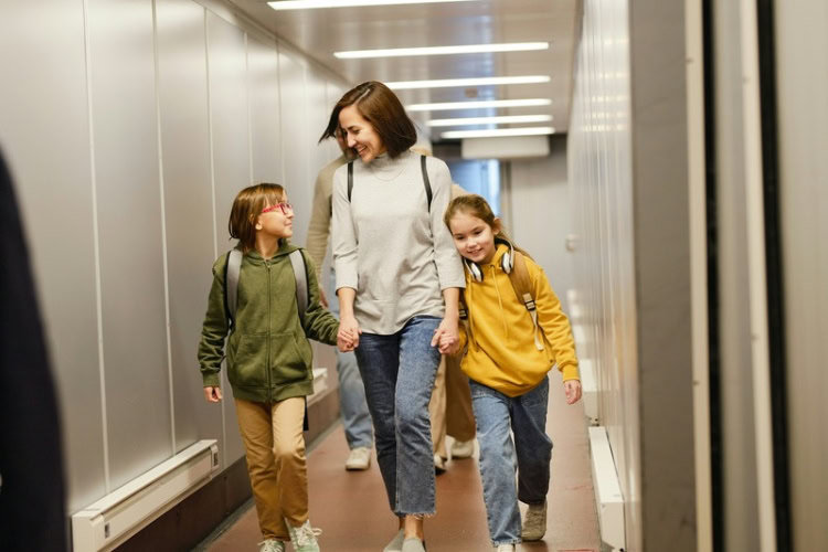 Mother walking with her children at the airport terminal. Photo by Getty Images, Unsplash