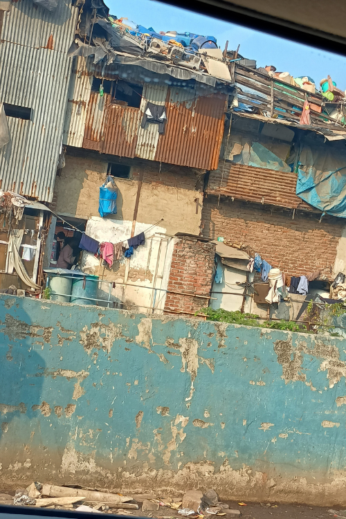 On the edge of Dharavi Slum, ramshackle dwellings hug the embankment of the Mahim Creek