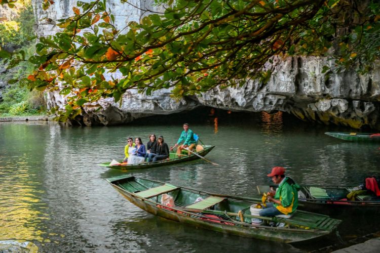 Visitors board a sampan to tour the river and caves.